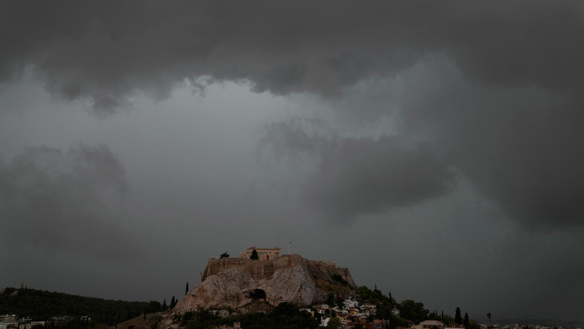 Graue Wolken bedecken den Himmel über dem Akropolis-Hügel während eines Regenschauers.