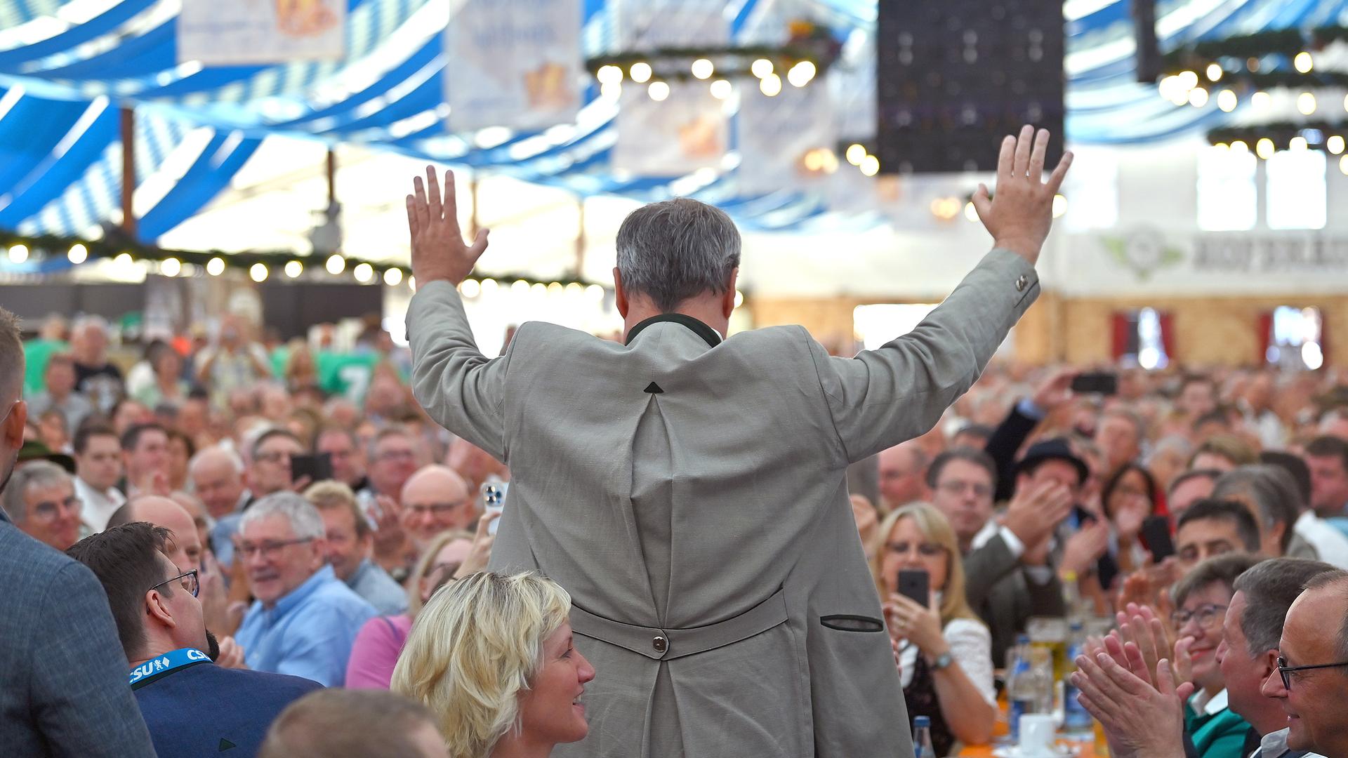 Der Ministerpräsident von Bayern, Markus Söder, lässt sich mit ausgebreiteten Armen in einem Bierzelt feiern.