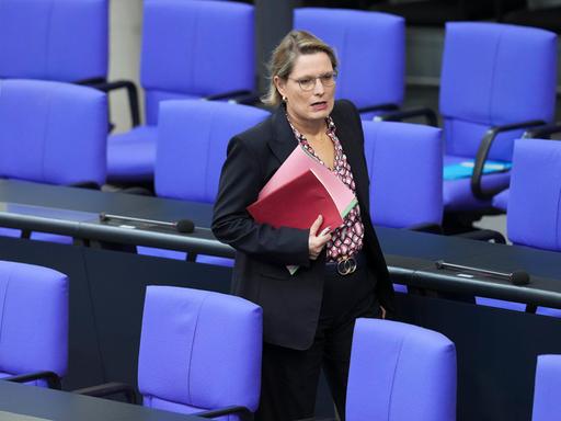Dr. Stefanie Hubig, Bundesministerin der Justiz und für Verbraucherschutz läuft mit einer Mappe unter dem Arm durch eine Sitzreihe im Deutschen Bundestag Dr. Stefanie Hubig, Bundesministerin der Justiz und für Verbraucherschutz läuft mit einer Mappe unter dem Arm durch eine Sitzreihe im Deutschen Bundestag