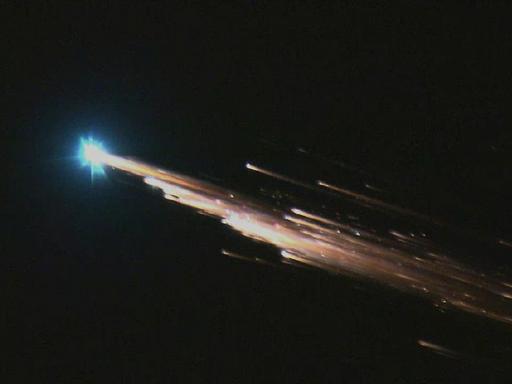 Eintritt eines Satelliten in die Erdatmosphäre, ein glühender Schweif ist am Nachthimmel zu sehen.