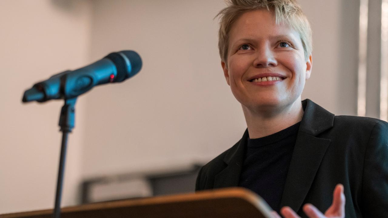 Eine junge Frau mit blonden Haaren vor einem Mikrofon