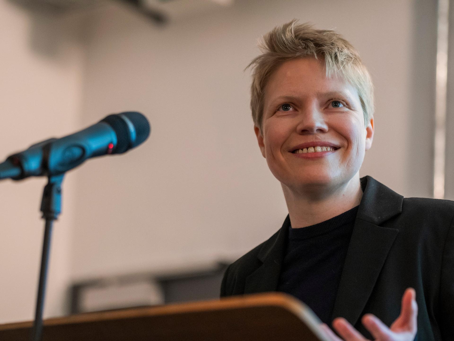 Eine junge Frau mit blonden Haaren vor einem Mikrofon
