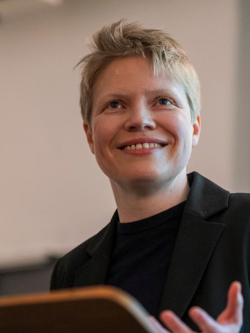 Eine junge Frau mit blonden Haaren vor einem Mikrofon