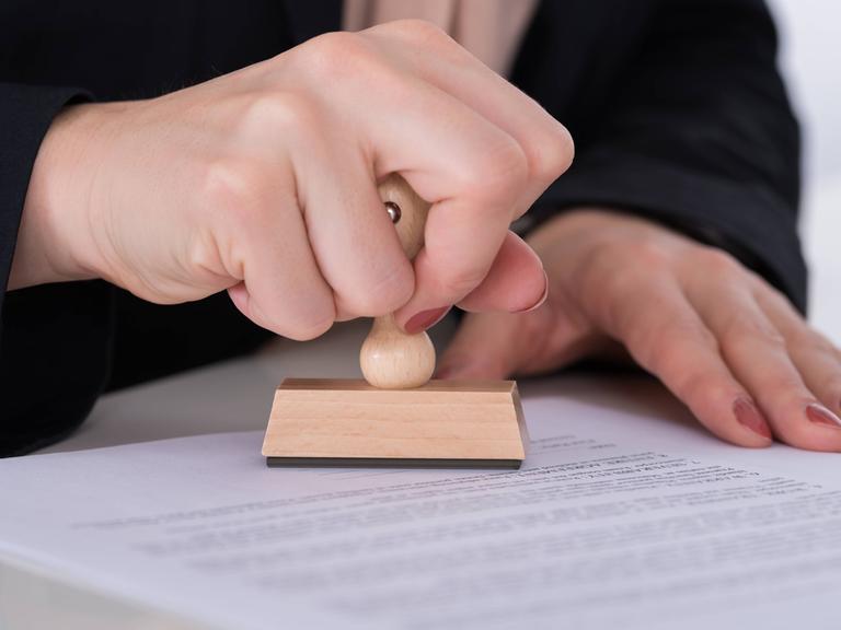 Ein Beschäftigter stempelt ein Dokument