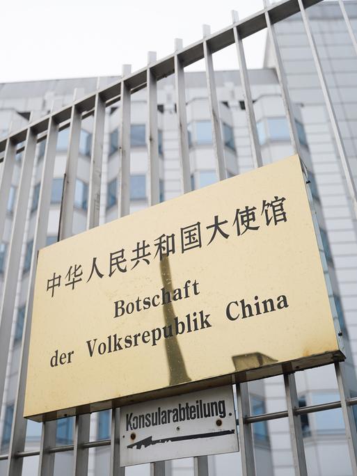 An einem Zaun ist ein Schild mit der Aufschrift "Botschaft der Volksrepublik China" befestigt. An einem Zaun ist ein Schild mit der Aufschrift "Botschaft der Volksrepublik China" befestigt.
