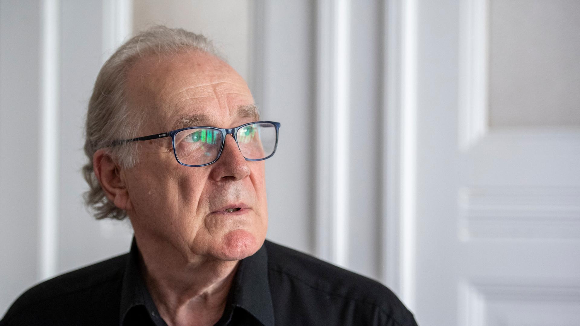 Ein älterer Heer mit Brille und grauen Haaren schaut zur Seite. Ein älterer Heer mit Brille und grauen Haaren schaut zur Seite.