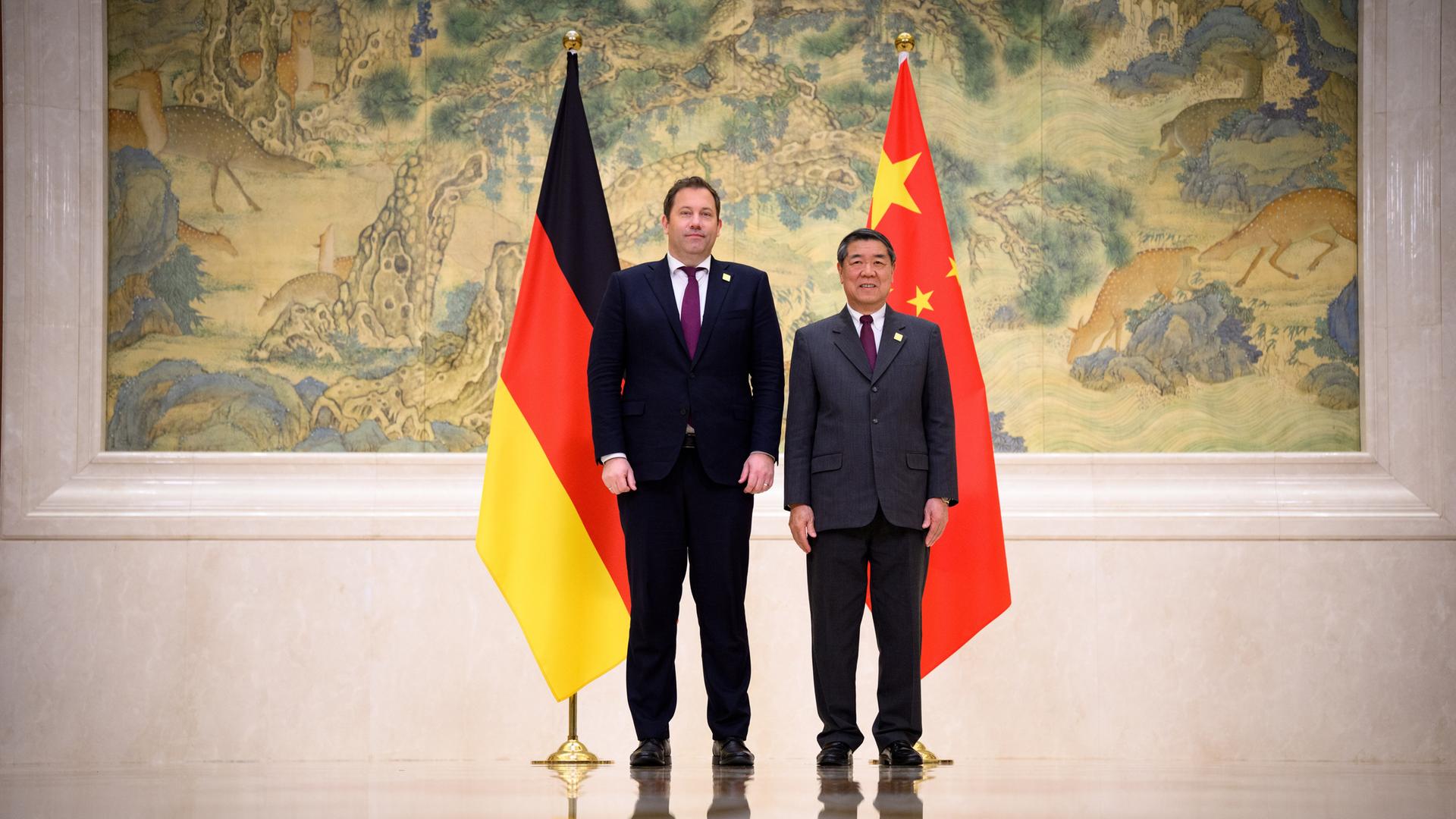 Bundesfinanzminister Lars Klingbeil (l, SPD) und  Chinas Vize-Premierminister He Lifeng, an der SEite die Fahnen beider Länder. 