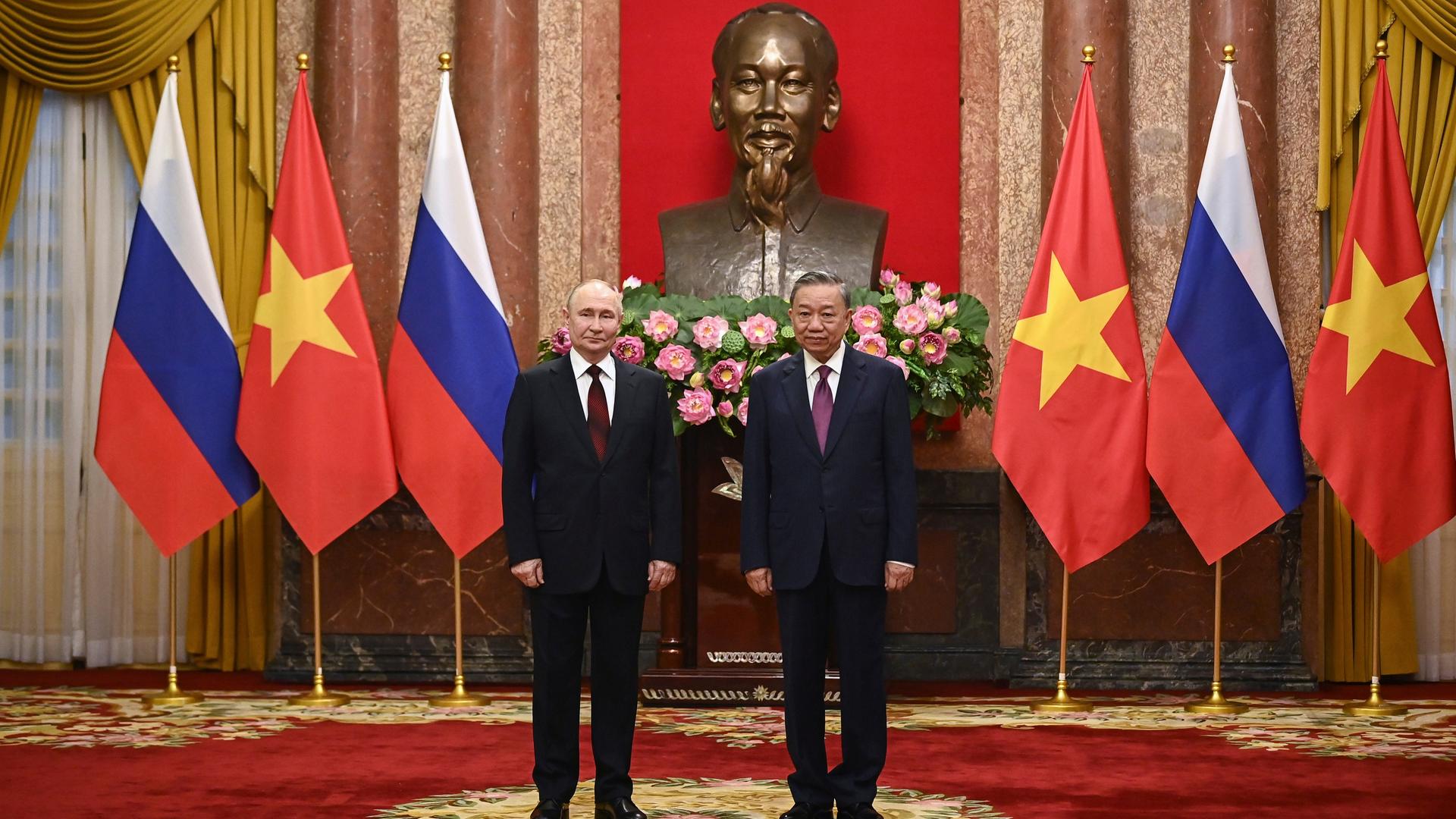 Der russische Präsident Wladimir Putin steht links neben dem vietnamesischen Präsident To Lam in Hanoi. Hinter ihnen sind russische und vietnamesiche Flaggen. Der russische Präsident Wladimir Putin steht links neben dem vietnamesischen Präsident To Lam in Hanoi. Hinter ihnen sind russische und vietnamesiche Flaggen.