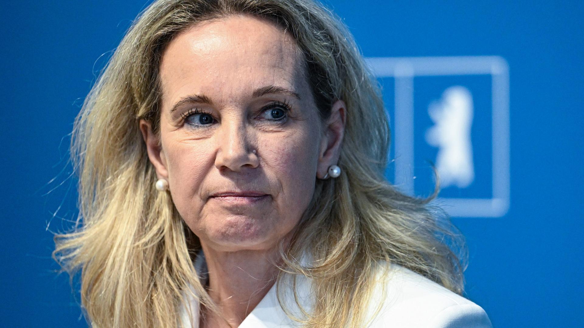 Sarah Wedl-Wilson sitzt auf einem Podium vor einer blauen Wand auf der "Berlin" steht Sarah Wedl-Wilson sitzt auf einem Podium vor einer blauen Wand auf der "Berlin" steht