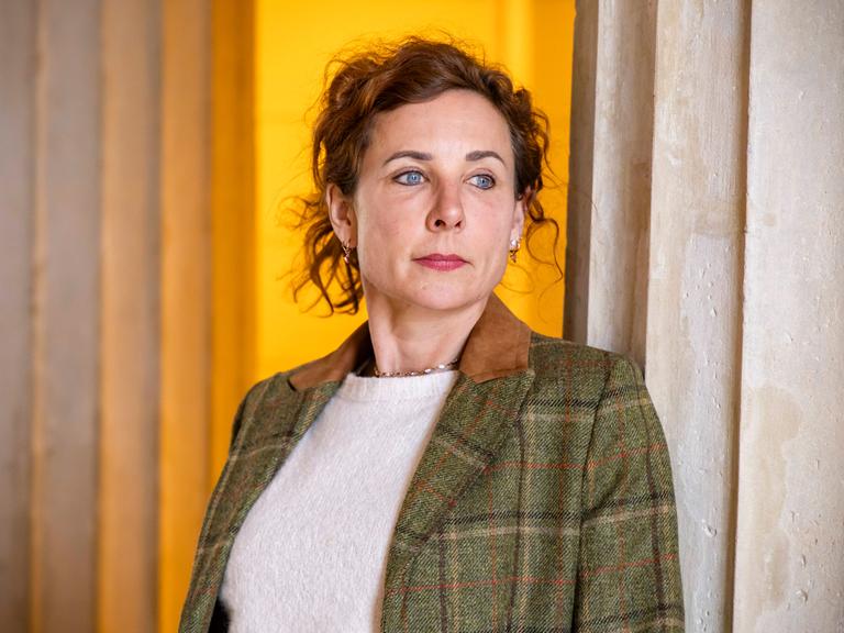 Die Schriftstellerin Juli Zeh lehnt zwischen zwei antiken Säulen