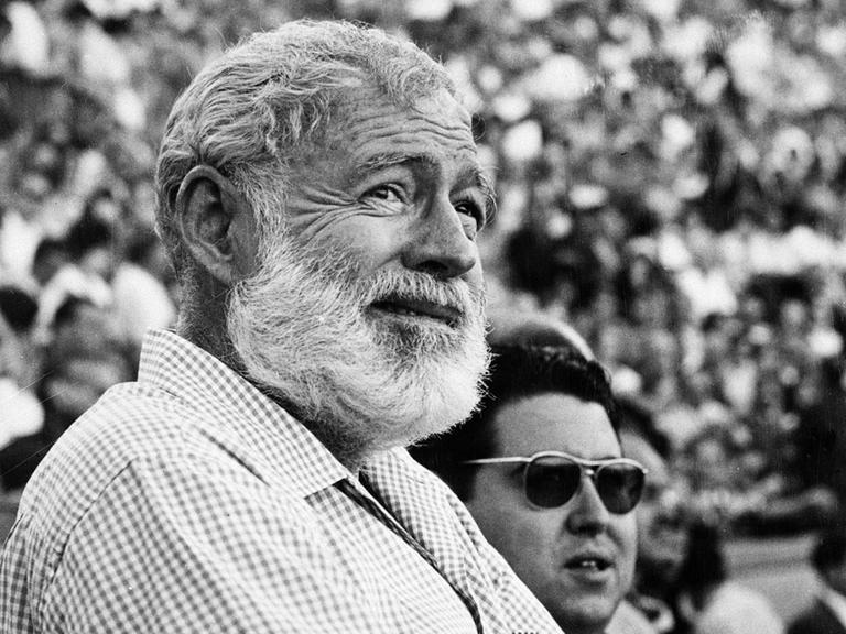 Schwarzweißporträt von Ernest Hemingway als älterem Mann in einem Stadion.