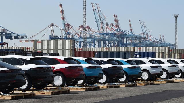 Porsche-Fahrzeuge stehen vor ihrer Verladung in Container auf Paletten im Hafen