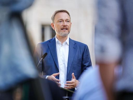 Christian Lindner (FDP), Bundesminister der Finanzen, steht hinter einem Mikrofon und spricht mit Journalisten.