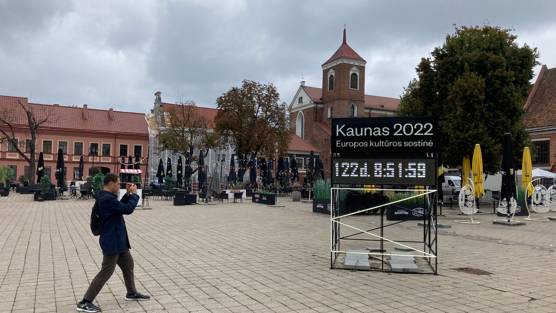 Ein Mann fotografiert eine Tafel mit der Aufschrift "Kaunas 2022" mit einem Countdown bis zum Beginn des Kulturhauptstadtjahres.