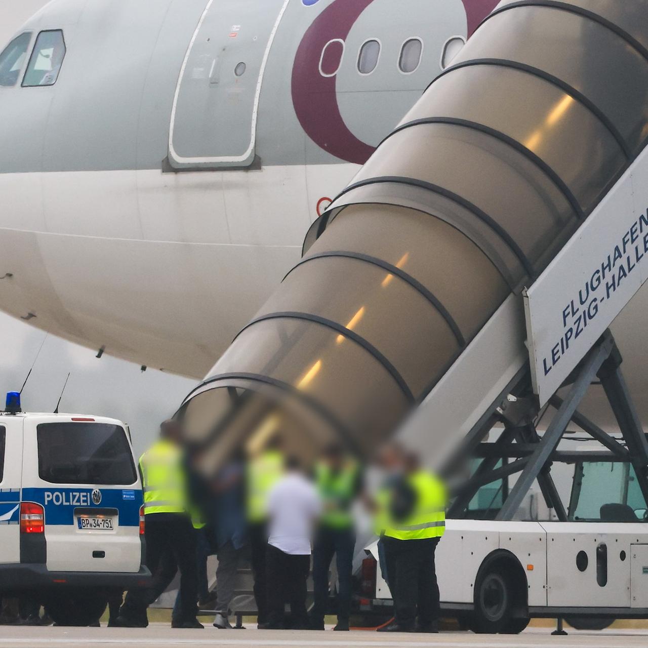 Schkeuditz: Menschen besteigen ein Flugzeug der Qatar Airways, vor dem Fahrzeuge der Bundespolizei stehen auf dem Vorfeld am Flughafen Leipzig/Halle.