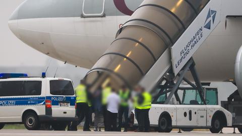 Schkeuditz: Menschen besteigen ein Flugzeug der Qatar Airways, vor dem Fahrzeuge der Bundespolizei stehen auf dem Vorfeld am Flughafen Leipzig/Halle.