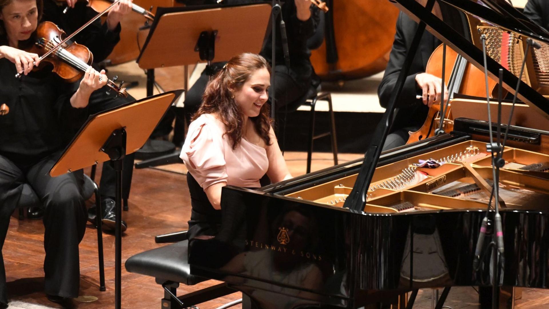Blick auf die am Flügel sitzende und dabei strahlende Pianistin während ihres Auftrittes mit dem Mahler Chamber Orchestra. Blick auf die am Flügel sitzende und dabei strahlende Pianistin während ihres Auftrittes mit dem Mahler Chamber Orchestra.