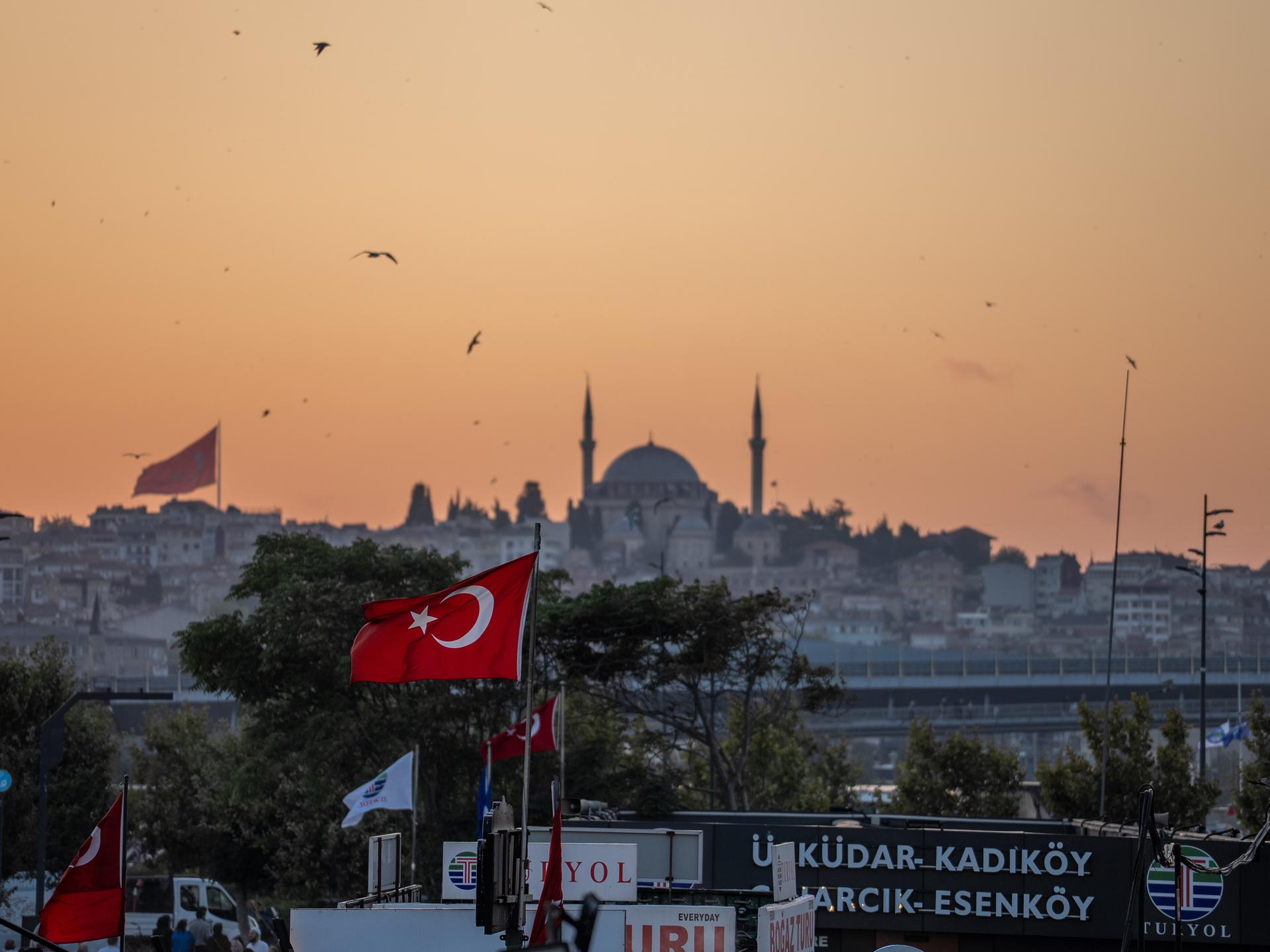 Die Yavuz-Sultan-Selim-Moschee in Istanbul und eine türkische Flagge bei Sonnenuntergang Die Yavuz-Sultan-Selim-Moschee in Istanbul und eine türkische Flagge bei Sonnenuntergang