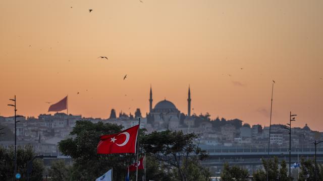 Die Yavuz-Sultan-Selim-Moschee in Istanbul und eine türkische Flagge bei Sonnenuntergang