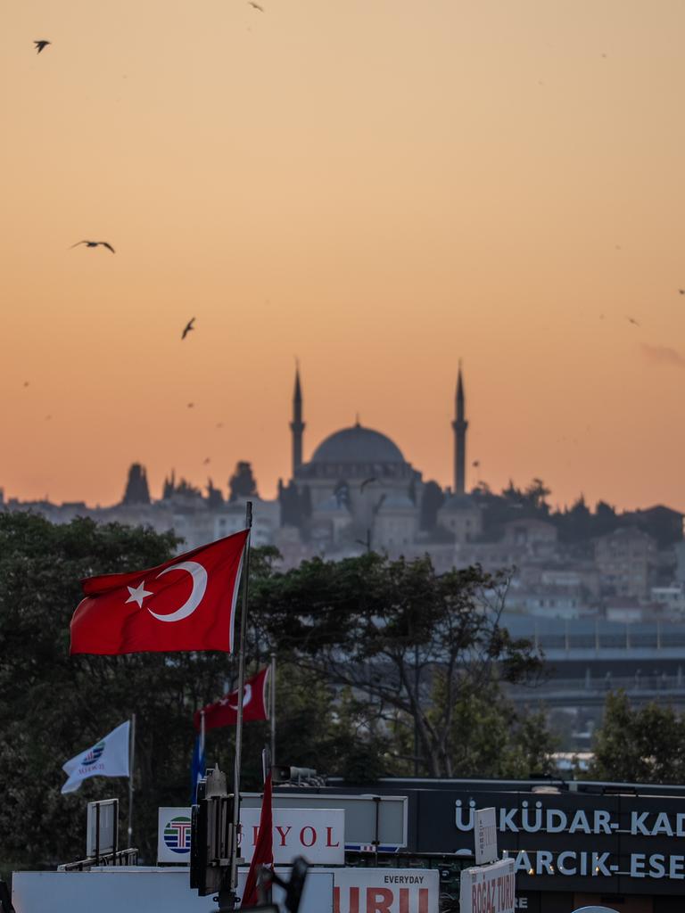 Die Yavuz-Sultan-Selim-Moschee in Istanbul und eine türkische Flagge bei Sonnenuntergang