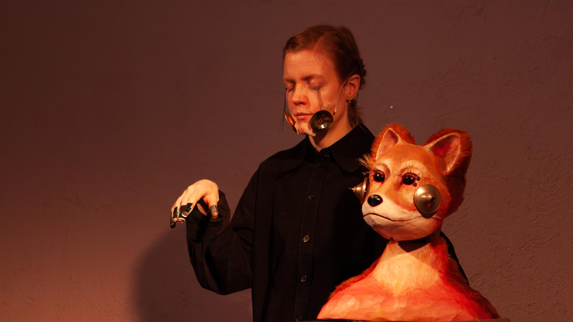 Eine Darstellerin und ihre Puppe, deren Gesichter mit kleinen Instrumenten präpariert sind Eine Darstellerin und ihre Puppe, deren Gesichter mit kleinen Instrumenten präpariert sind