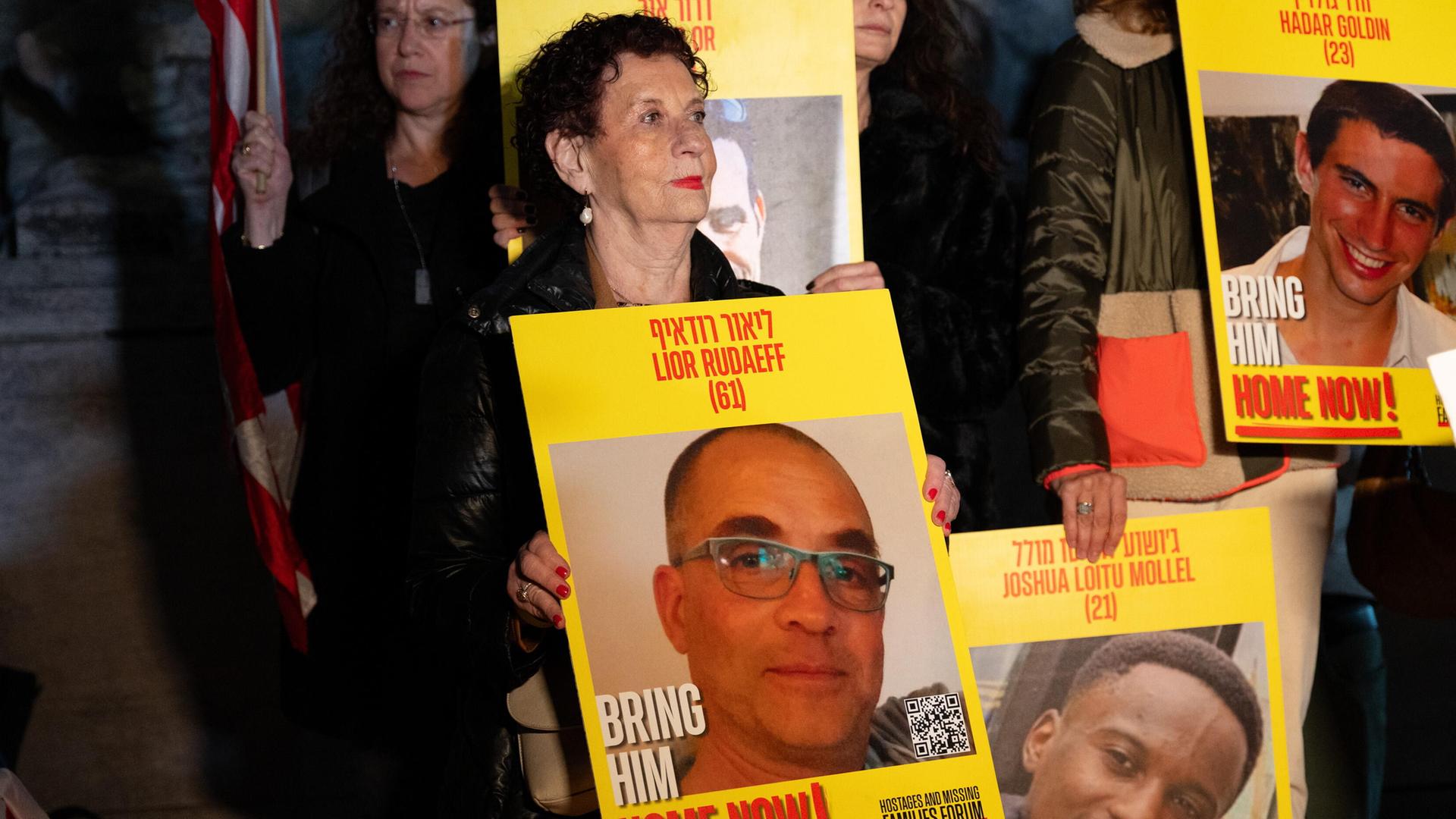 Eine Frau hält ein Schild mit dem Porträt der verstorbenen Geisel Lior Rudaeff. Eine Frau hält ein Schild mit dem Porträt der verstorbenen Geisel Lior Rudaeff.