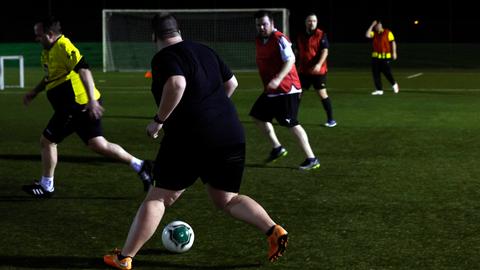 Mehrere Männer laufen beim Fußballtraining über den Platz.