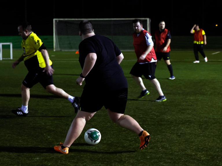 Mehrere Männer laufen beim Fußballtraining über den Platz.