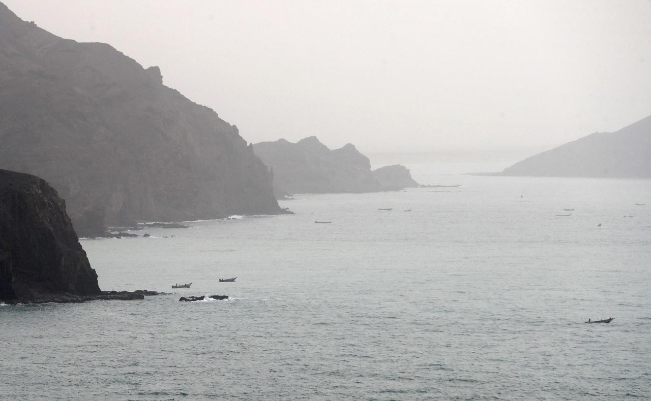 Links und rechts hohe Felsen, auf dem Wasser einige Fischerboote. Links und rechts hohe Felsen, auf dem Wasser einige Fischerboote.