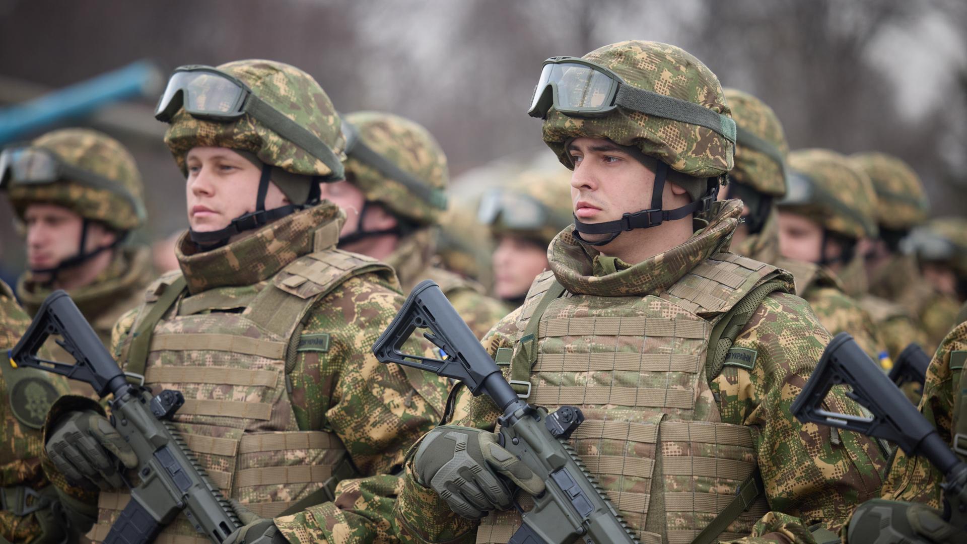 Ukrainische Soldaten in Kampfmontur mit Gewehren. 