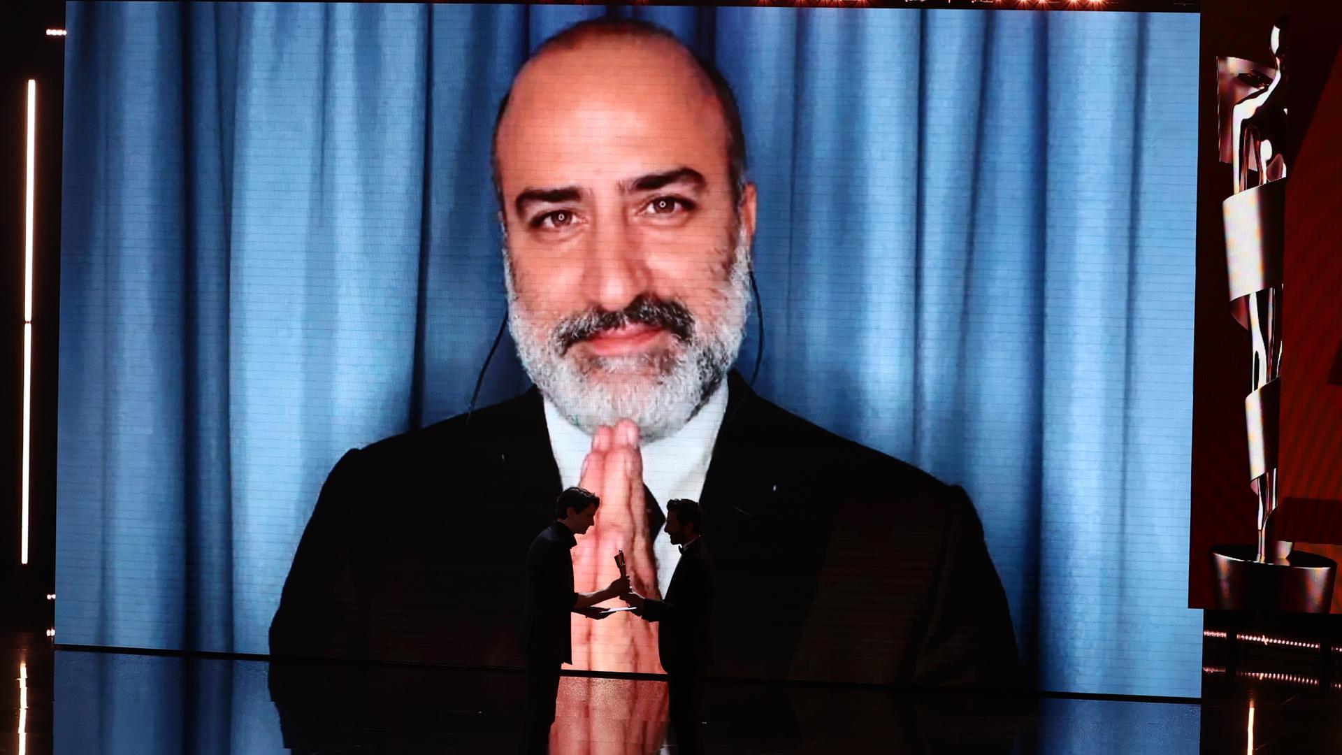 Aus dem Iran zugeschaltet: Misagh Zare bedankt sich für die Lola für die beste männliche Hauptrolle in dem Film "Die Saat des heiligen Feigenbaums" während der 75. Verleihung des Deutschen Filmpreises in Berlin