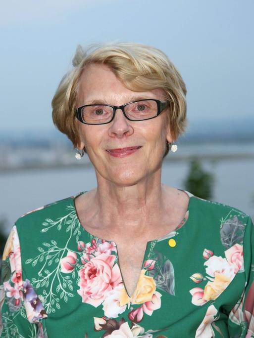 Frontalansicht Dr. Regula Venske im grünen, geblümten Kleid. Sommer 2018 auf dem Suellberg Hamburg.