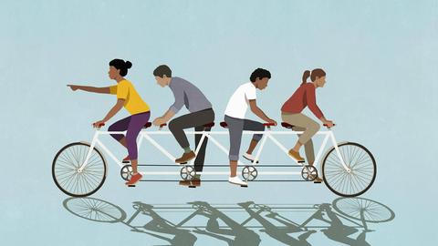 Illustration von vier Menschen auf einem viersitzigen Fahrrad, wobei zwei nach rechts und zwei nach links treten (Symbolbild)