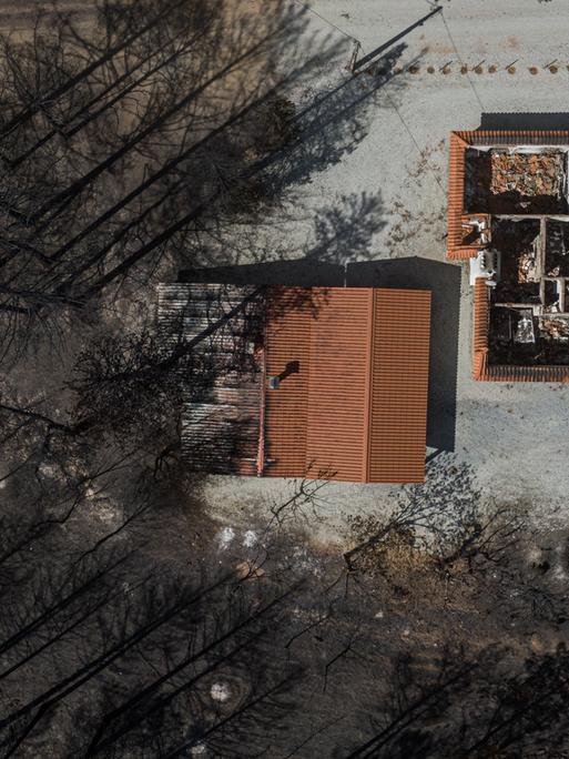 Ein Luftbild zeigt zerstörte Gebäude inmitten eines verbrannten Waldes, nachdem extreme Waldbrände am 25. Juli 2022 in Murca, Portugal, riesige Landstriche verschlungen haben. Seit Beginn der diesjährigen Sommersaison sind in Portugal mehr als 57 940 Hektar verbrannt, was die Brandfläche des Jahres 2021 bei weitem übertrifft. 
