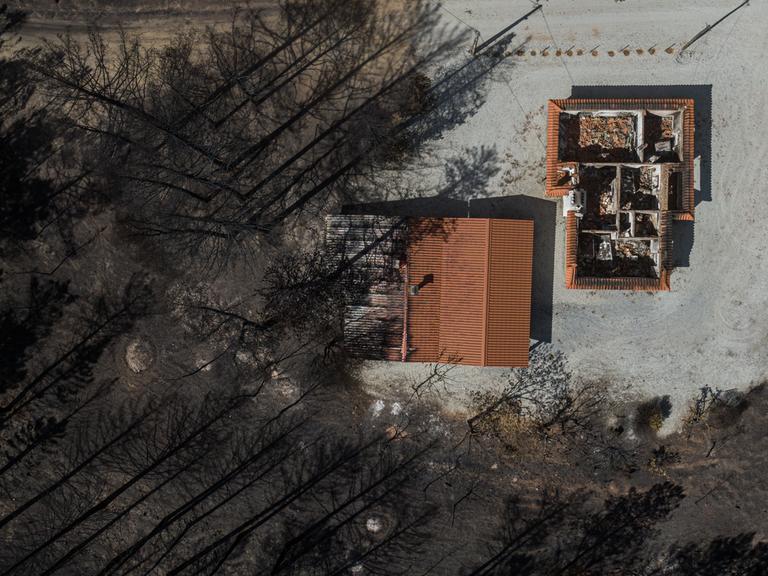 Ein Luftbild zeigt zerstörte Gebäude inmitten eines verbrannten Waldes, nachdem extreme Waldbrände am 25. Juli 2022 in Murca, Portugal, riesige Landstriche verschlungen haben. Seit Beginn der diesjährigen Sommersaison sind in Portugal mehr als 57 940 Hektar verbrannt, was die Brandfläche des Jahres 2021 bei weitem übertrifft. 