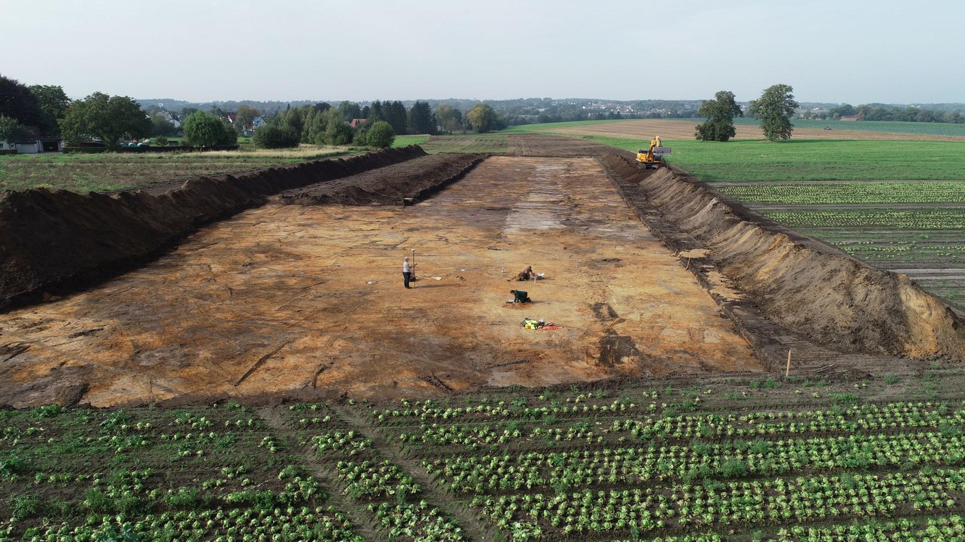 Drohnenaufnahme eines Felds, aus dem in einem rechteckigen Bereich die oberste Erdschicht abgetragen wurde. Foto: LWL-Archäologie für Westfalen Drohnenaufnahme eines Felds, aus dem in einem rechteckigen Bereich die oberste Erdschicht abgetragen wurde. Foto: LWL-Archäologie für Westfalen