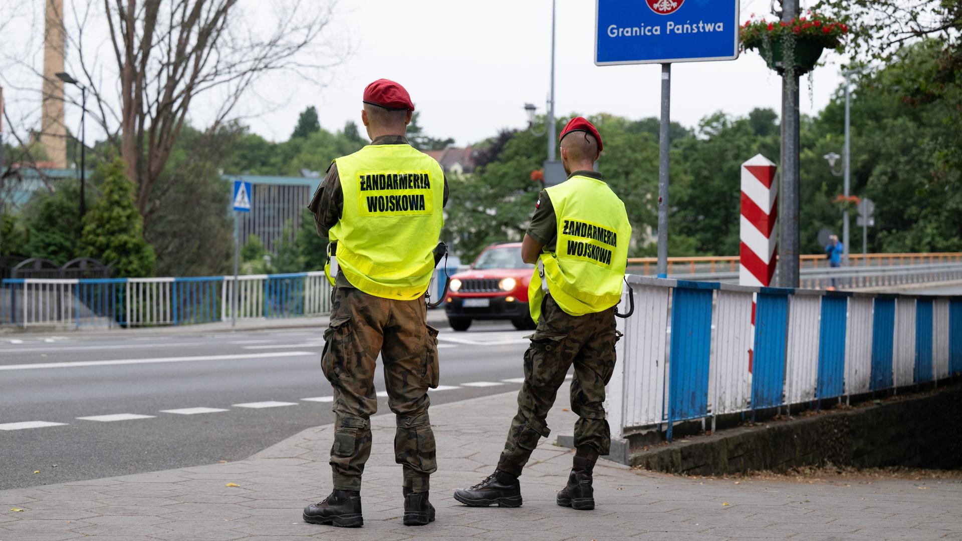 Polnische Grenzschützer stehen auf der polnischen Seite hinter der Stadtbrücke von Görlitz und beobachten den Verkehr. Polnische Grenzschützer stehen auf der polnischen Seite hinter der Stadtbrücke von Görlitz und beobachten den Verkehr.