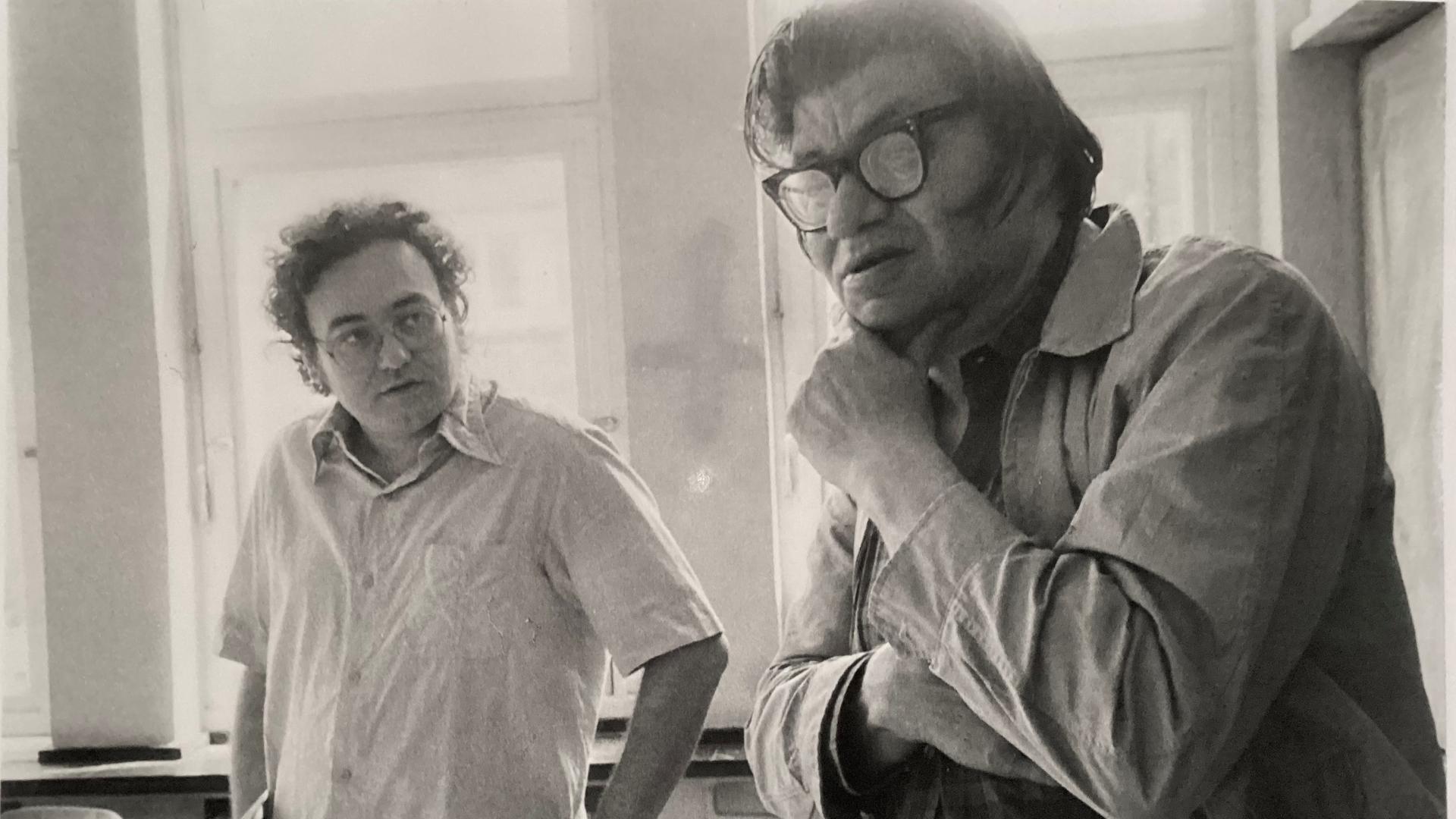 Walter Zimmermann schaut fragend auf Morton Feldman, der nachdenklich mit der Hand sein Kinn hält Walter Zimmermann schaut fragend auf Morton Feldman, der nachdenklich mit der Hand sein Kinn hält