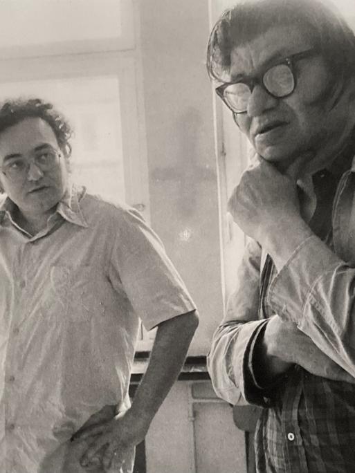 Walter Zimmermann schaut fragend auf Morton Feldman, der nachdenklich mit der Hand sein Kinn hält