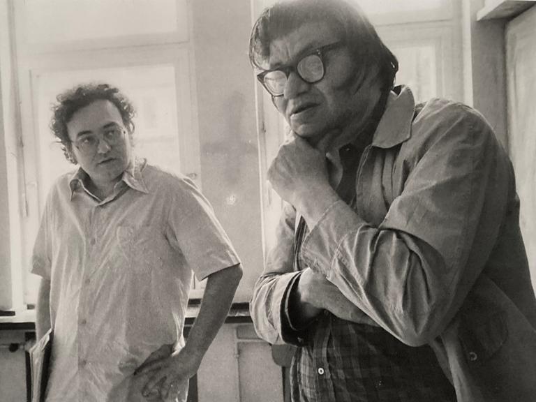 Walter Zimmermann schaut fragend auf Morton Feldman, der nachdenklich mit der Hand sein Kinn hält