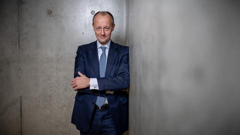 Der CDU-Politiker Friedrich Merz steht im Jakob-Kaiser-Haus des Deutschen Bundestags vor einer grauen Betonwand und verschränkt die Arme.