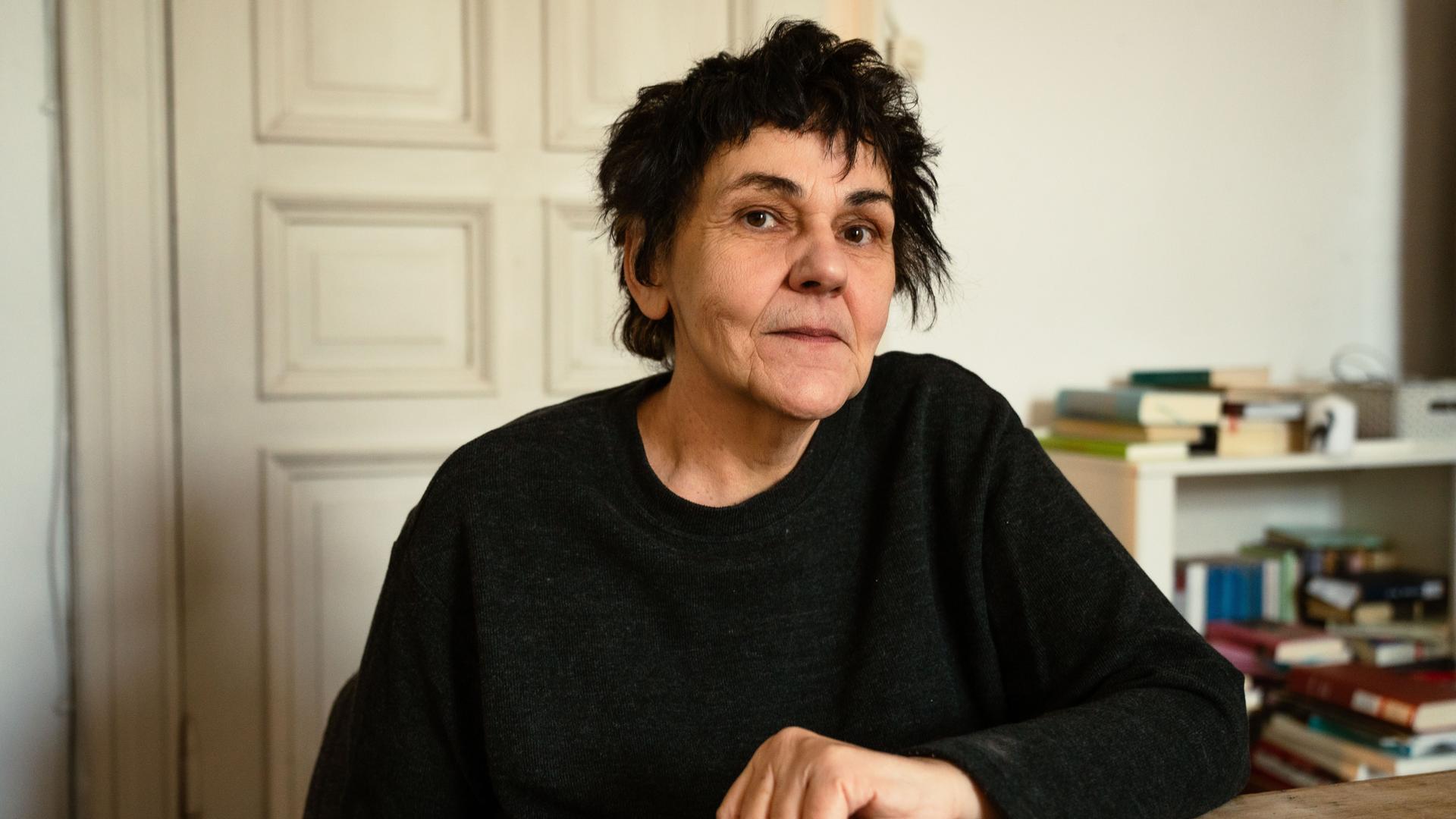 Christiane Rösinger sitzt an einem Tisch und schaut in die Kamera Christiane Rösinger sitzt an einem Tisch und schaut in die Kamera