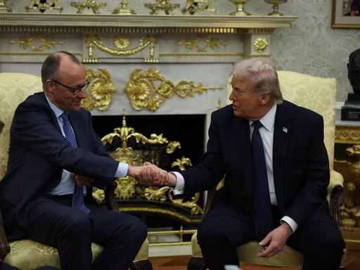 US-Präsident Donald Trump und Bundeskanzler Friedrich Merz sitzen nebeneinander und reichen sich die Hand US-Präsident Donald Trump und Bundeskanzler Friedrich Merz sitzen nebeneinander und reichen sich die Hand