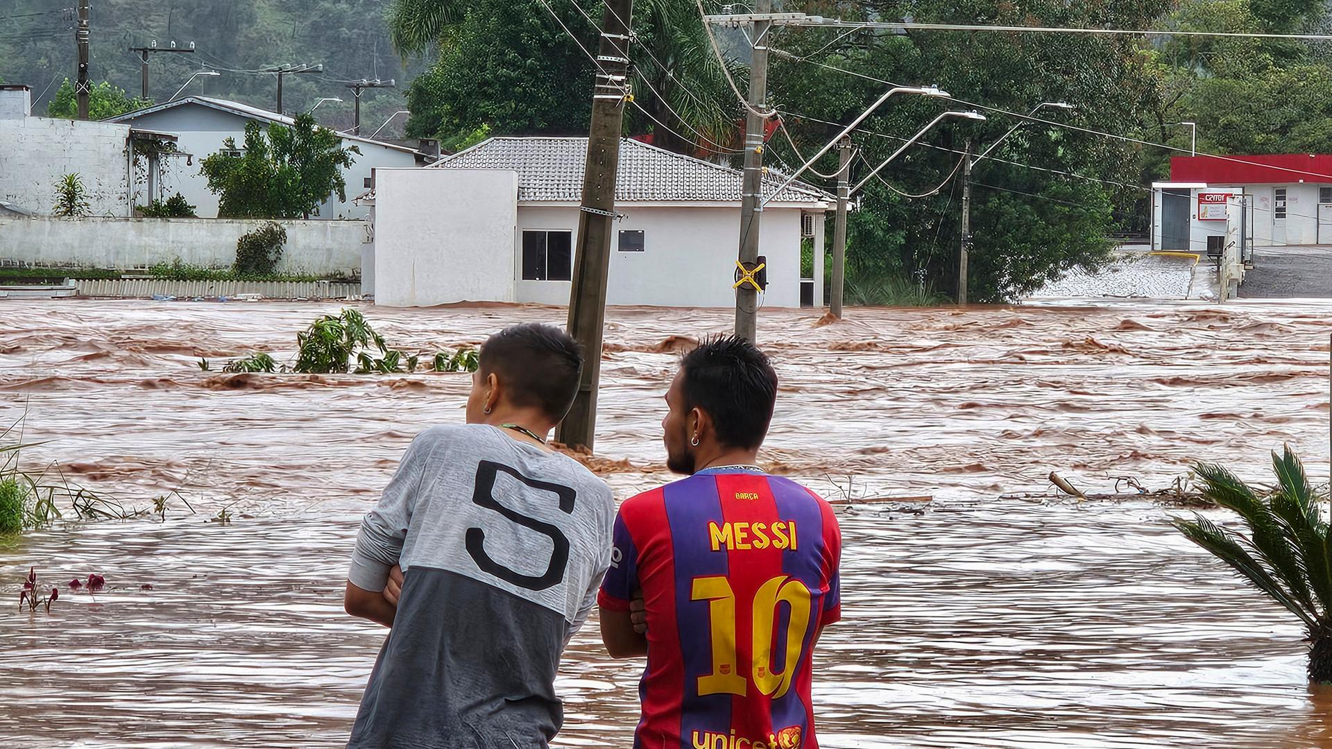 Zwei Männer beobachten die überschwemmten Straßen in der Kleinstadt Encantado 