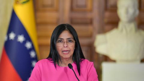 Delcy Rodriguez spricht bei einer Pressekonferenz in Caracas, im Hintergrund ist eine venezolanische Flagge zu sehen.