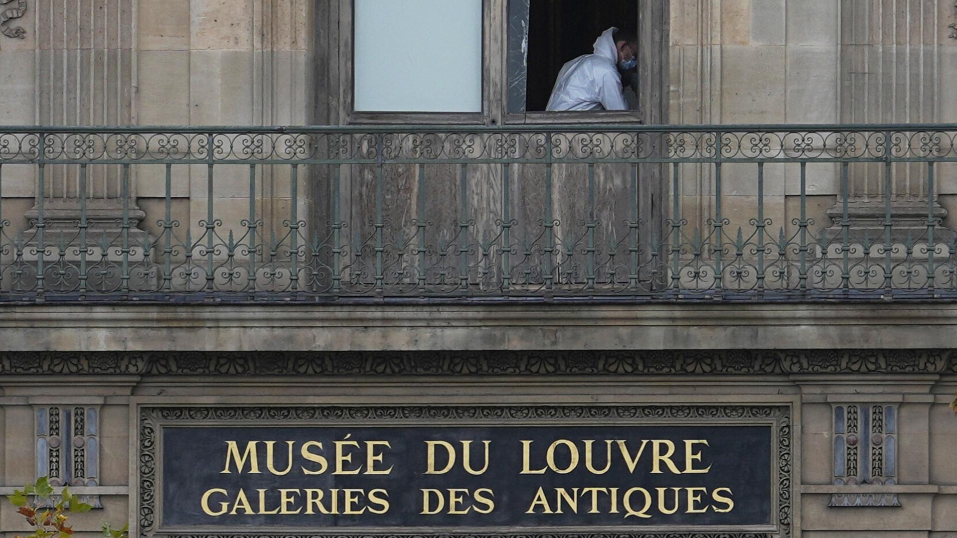 Ein Polizeibeamter in einem weißen Schutzanzug sichert im Pariser Louvre Spuren