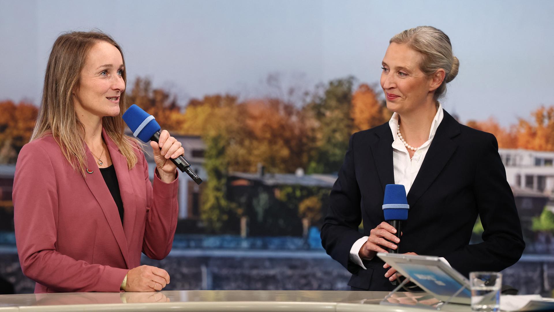 Claudia Wittig steht neben Alice Weidel und hält ein Mikrofon in der Hand. Claudia Wittig steht neben Alice Weidel und hält ein Mikrofon in der Hand.