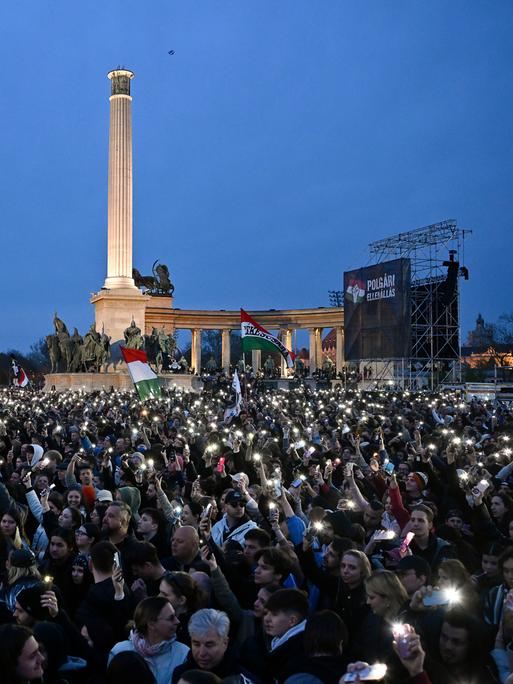 Tausende Menschen bei einem regierungskritischen Konzert auf dem Budapester Heldenplatz, viele halten leuchtende Handys in den dunklen Nachthimmel.