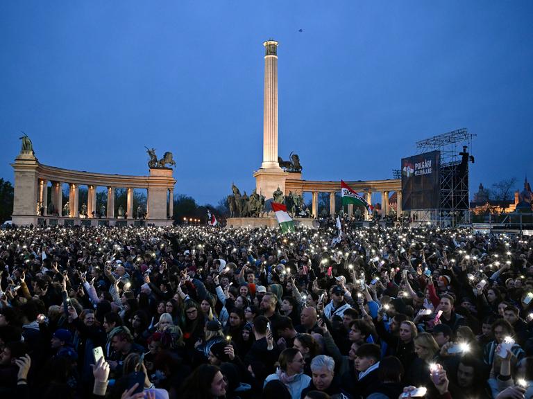 Tausende Menschen bei einem regierungskritischen Konzert auf dem Budapester Heldenplatz, viele halten leuchtende Handys in den dunklen Nachthimmel.