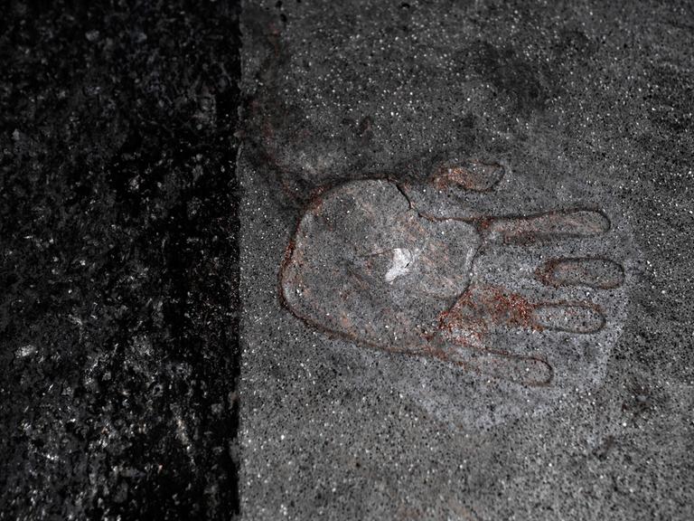 Hinterlassener Handabdruck einer mit Sekundenkleber festgeklebten Hand von einem Klimademonstranten der Letzten Generation auf dem Asphalt einer Strasse in Berlin Mitte Deutschland.